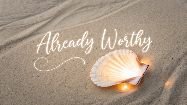 Glowing seashell on sandy beach with the words Already Worthy - Powered by Adobe