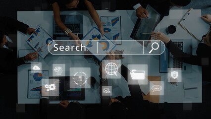 A diverse business team collaborates over data analysis documents, utilizing laptops and a digital search interface, showcasing teamwork and innovation in a modern workspace. Raster