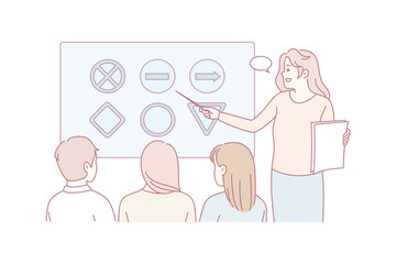 white female teacher pointing at board while teaching shapes to students, small group facing chart, teacher