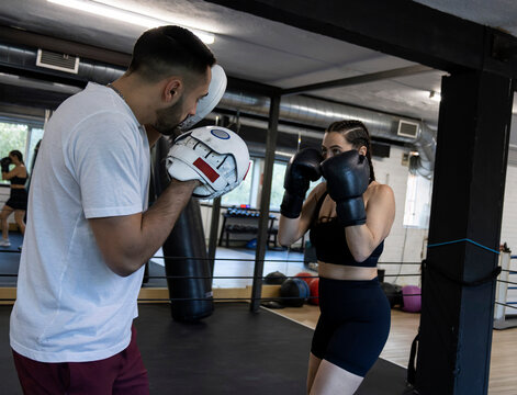 Caucasian male trainer coaching female boxer during training session