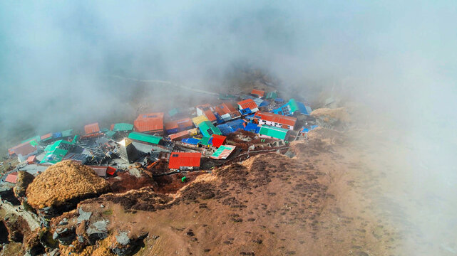 Aerial drone of mountainside, village town with colorful houses and thick cloud cover in Chopta on Tungnath trek Uttarakhand India - Powered by Adobe