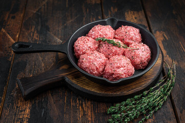 Groundmeat meatballs or Frikadel in cast iron pan on wooden board offering detailed texture ideal for grocery, cooking and nutrition imagery.
