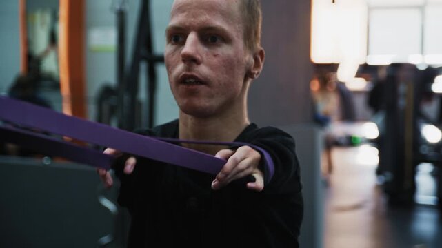 Shot of adaptive fitness in action. An athlete with a limb difference works on lower body strength using a leg press machine, assisted by a personal trainer. Highlights accessibility and determination