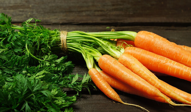 A bunch of carrots on a wooden background - Powered by Adobe