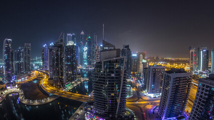Aerial view of Dubai Marina residential and office skyscrapers with waterfront night timelapse