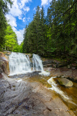Obraz premium Water falling over rocks in Harrachov forest