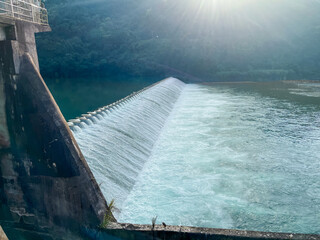 Early morning view of Zhihtan Weir Dam gates and turquoise reservoir surrounded by lush green mountains in Xindian District, New Taipei City, Taiwan.