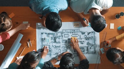 Top view of civil engineer writing and planning by using sticky notes to brainstorm idea. Top down aerial view of business people taking a note at table with project plans and equipments. Symposium.