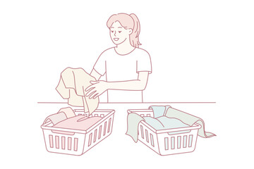 woman folding donated clothes at table, sorting items into baskets while focused and calm. soft pastel