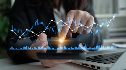 Business professional uses a smartphone to analyze financial data with a graph overlay, symbolizing growth strategies in a contemporary office space. Scalp