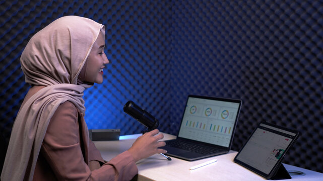 Hijab businesswoman working at desk with laptop and tablet – modern office workspace, productivity and professional Muslim woman