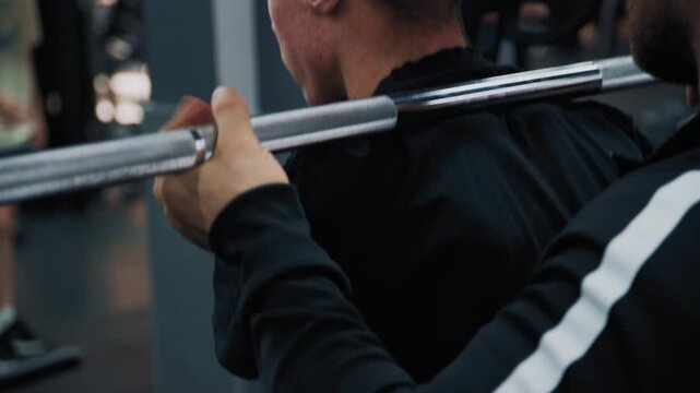 Shot of adaptive fitness in action. An athlete with a limb difference works on lower body strength using a leg press machine, assisted by a personal trainer. Highlights accessibility and determination