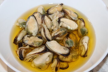 Fresh mussels in flavorful broth served in a bowl at a seaside restaurant during a sunny afternoon