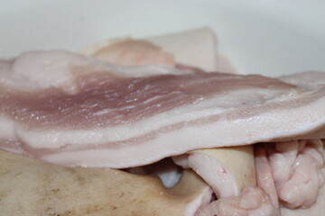 Fresh raw pork belly prepared for cooking in a kitchen environment, ready to be seasoned and grilled