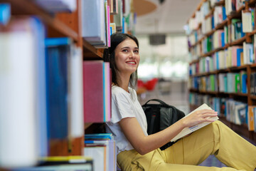 Caucasian female student reading a book alone in a quiet library, capturing education, concentration, and academic lifestyle. Ideal for themes about studying, learning environments, school marketing, 