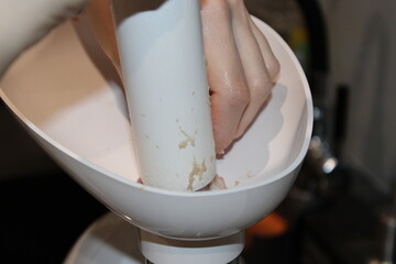 Preparing ingredients with a kitchen tool in a cozy home kitchen setting during the evening
