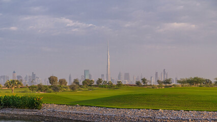 Beautiful golf course during sunrise around modern skyscrapers of Dubai Downtown timelapse in luxury Dubai city, United Arab Emirates