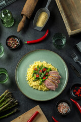 Duck breast with couscous and asparagus, overhead view