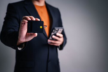 Businessman holding a smart card reader and smartphone, demonstrating secure digital authentication technology for financial transactions, data access, or digital identity verification.