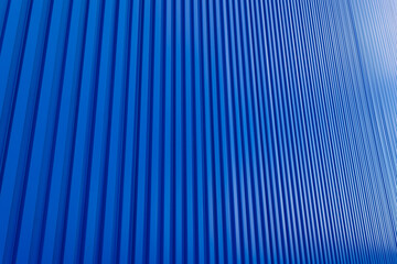 Blue building zinc wall backdrop,Corrugated metal sheet wall. Background of blue corrugated steel sheets with diagonal corrugations as wall of modern building with copy space. Selective focus