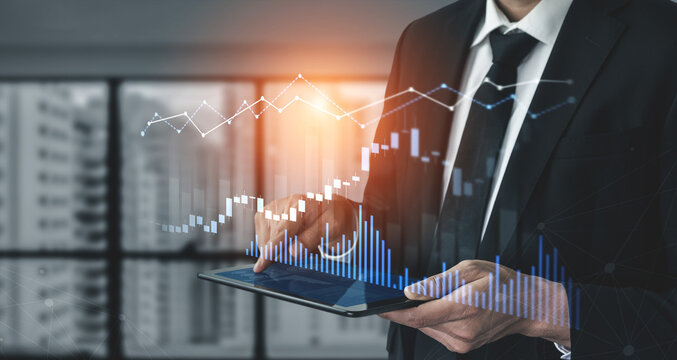 A business professional reviews financial data on a tablet, showcasing digital charts and graphs in a contemporary office environment, highlighting analytical insights. Scalp
