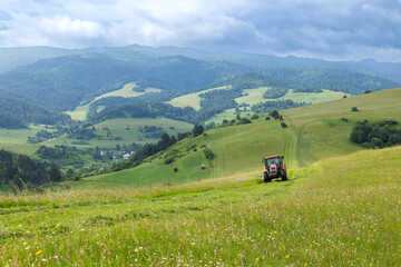Tractor working on green hillside in Lesnica, Slovakia