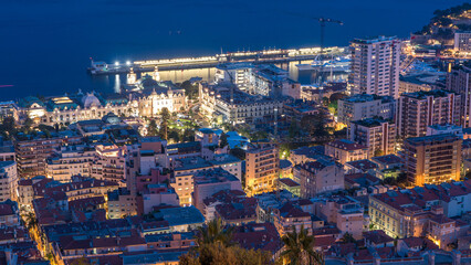 Obraz premium Cityscape of Monte Carlo, Monaco day to night timelapse with roofs of buildings after summer sunset.