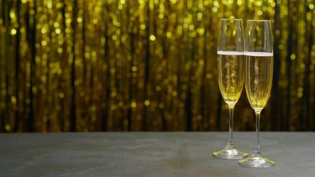  Champagne in a two glasses on a table in a blurred  holiday bokeh blinking background. - Powered by Adobe