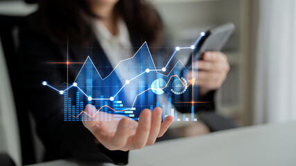 A business professional engages in financial analysis using digital graphs displayed on a smartphone in a modern office, showcasing a blend of technology and finance. Scalp