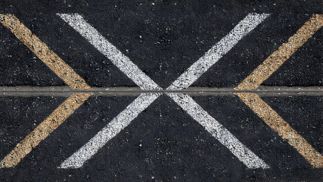 A simple roadway with repeating V-shaped arrow clusters creating sharp geometric patterns on asphalt