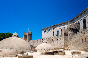 Historic stone bathhouse beside the ancient defensive walls of Baku Azerbaijan on a sunny day.