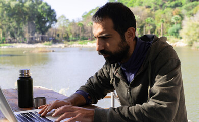 Side View of a Man Working From Anywhere While Camping or Traveling