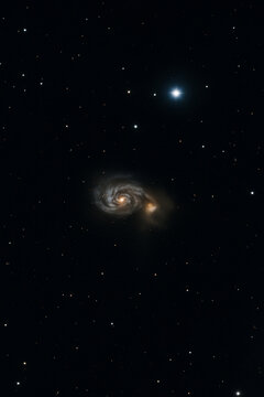 A stunning deep space photograph showing the Whirlpool Galaxy (Messier 51) and its companion galaxy against a dark star-filled sky