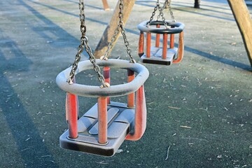 Frosty toddler swings on cold autumn morning playground scene