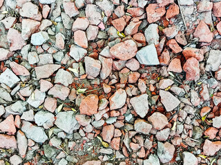 A close up view of broken bricks and small rocks on ground