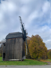old wooden windmill on the background of the autumn forest.