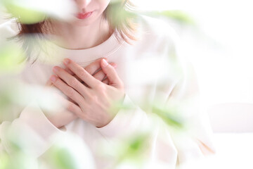 胸に手を当てる女性　不安、心配