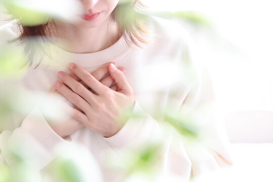 胸に手を当てる女性　不安、心配