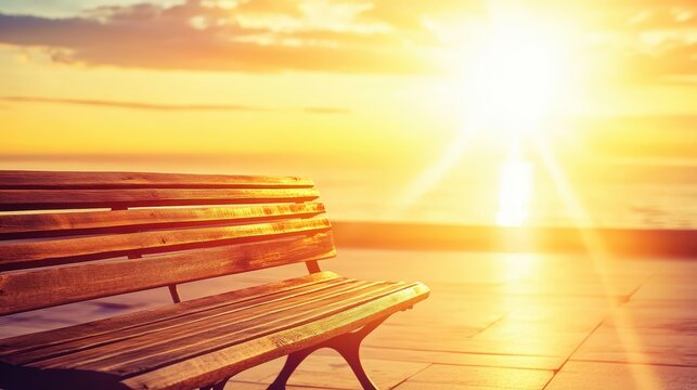 A solitary wooden bench overlooks the ocean at a vibrant golden sunset on a serene coastline