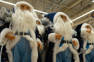 Christmas holiday decoration, toy shop. Santa Claus figurines on store counter
