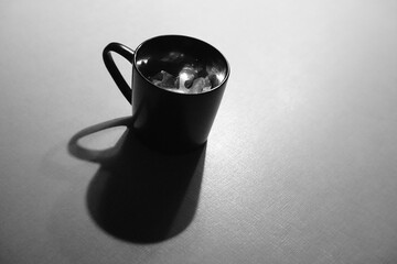 Minimalist black and white still life with black cup