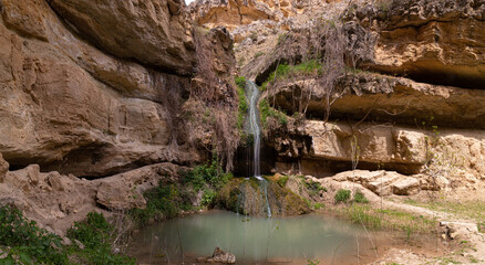 A small waterfall with a lake in the mountains.