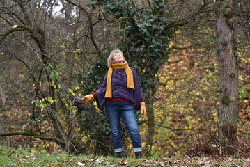 Woman looking up at the sky in an autumn park