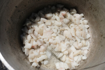 Cubed lard rendering in pot