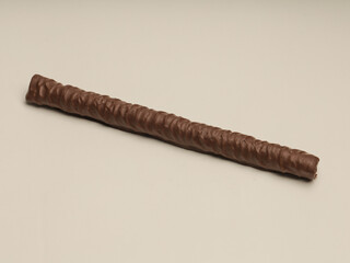 Wafer stick covered with ark chocolate on white background