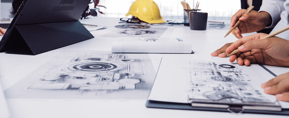 A vibrant office scene where diverse professionals engage in a brainstorming session, analyzing blueprints and sharing innovative ideas to drive project success. SACTR