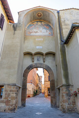 Obraz premium Ancient archway fresco opening to historic street in Pienza