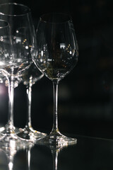 Empty wine glasses on reflective surface with dramatic light and da...
