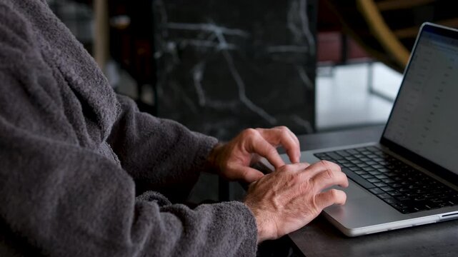 Laptop Beach Work: Woman types on laptop near ocean, remote work, scenic coastal setting.