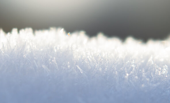 Macro shot of icy frost crystals on snow in soft morning light